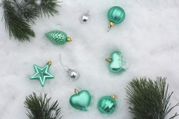 Christmas decor of silver, turquoise and gold. On snow. Top view, flat lay