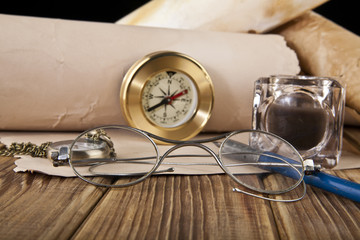 old glasses, paper, pen, clock and compass