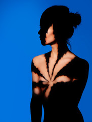 Beauty naked woman portrait. Light spot form like marijuana leaf. Blue backdrop. - 127923036