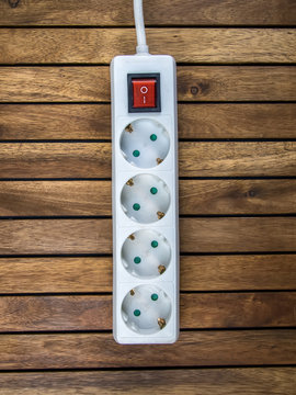 Regleta m&uacute;ltiple base de enchufes sobre tabla de madera