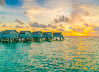 Beautiful water villas in tropical Maldives island at the sunset