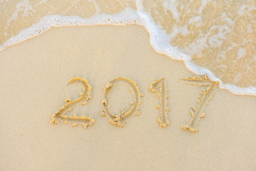 2017 text with white sandy beach and sea .