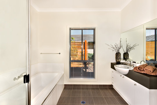 Modern bathroom with a water tub and bathing area opposite to th