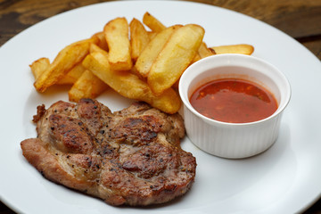 Grilled meat with French fries and sauce