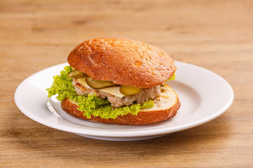Delicious original american hamburger with grilled beef, bacon and vegetables on white plate, snack or lunch, product photography for restaurant or bistro