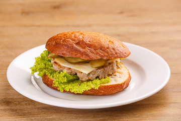 Delicious original american hamburger with grilled beef, bacon and vegetables on white plate, snack or lunch, product photography for restaurant or bistro