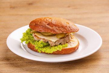 Delicious original american hamburger with grilled beef, bacon and vegetables on white plate, snack or lunch, product photography for restaurant or bistro