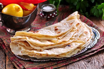 Homemade bread (pita, lavash bread) on old wooden background.