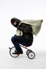 Thief in mask riding bicycle