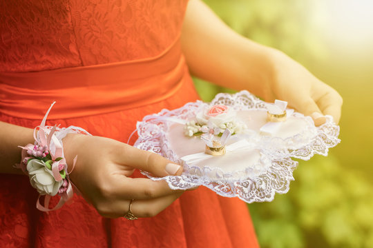 Close-up Of A Woman In A Red Dress Holding Wedding Rings