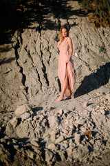 charming and young woman standing alone on sand quarry