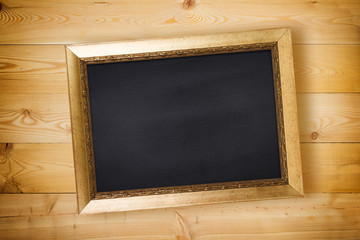 Chalkboard in vintage frame on wooden background