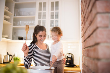 Obraz premium Mother with her daughter in the kitchen cooking together