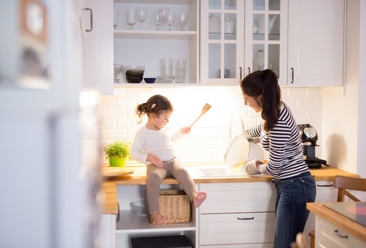 Mother with her daughter in the kitchen cooking together