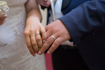 bride and groom show their wedding rings