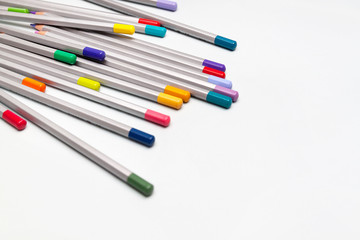color pencils are scattered on white table. Nobody. Antistress