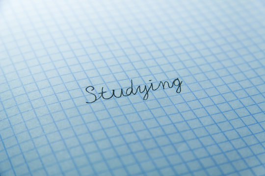 A word "studiying" on checked paper