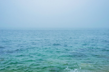 Fototapeta na wymiar Sea ocean water horizon sky storm fog mist aqua cyan turquoise texture background