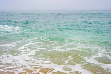 Sea ocean water wave foam sand beach horizon sky storm fog mist aqua cyan turquoise texture background