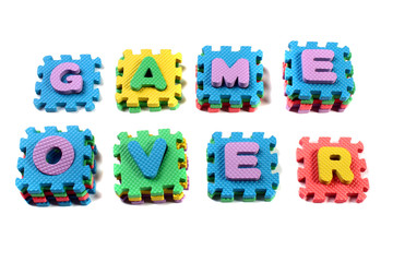 Words "Game Over" composed of cut out letters of toy plastic alphabet puzzle