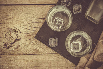 Fototapeta na wymiar Vodka in shot glasses on rustic wood background