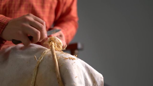 Basketry. View of boy cleans twig from bark