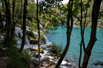 Waterfall and turquoise pond in the forest. Plitvice Lakes in National Park in Croatia.