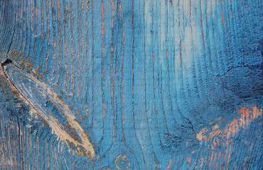Blue cracked paint on a wooden wall. 