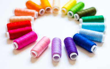 multicolored spools of thread on white background