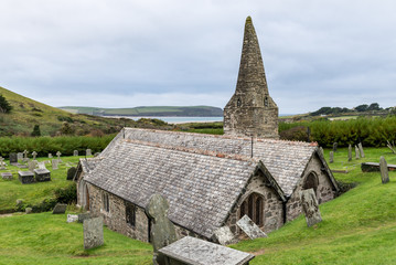 Fototapeta na wymiar The Church of St Enodoc is located amongst sand dunes adjacent to the Cornish village of Trebetherick.