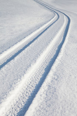 Car tire track on winter road