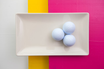 White ceramic dish with golf balls