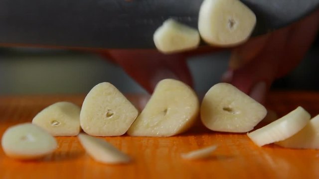 Woman is cutting garlic close-up in the kitchen