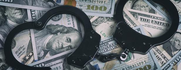 Handcuffs on money. US dollars