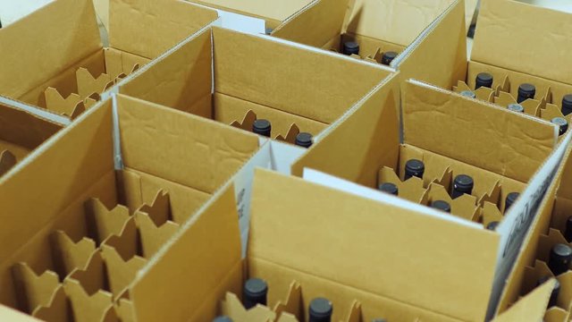 Bottles of wine are placed in cardboard boxes. Top view