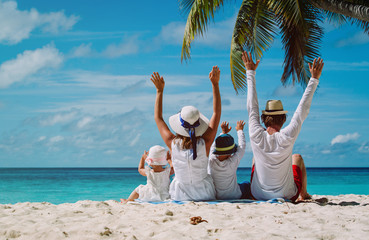 happy family with two kids hands up on the beach - 127937825