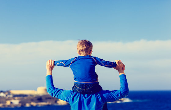 happy father and son on shoulders play at sky