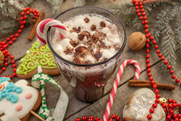 christmas background, composition. spruce branches, gingerbread (Snowman and Christmas tree), cocoa with cream and marshmallows, cinnamon, candy cane.