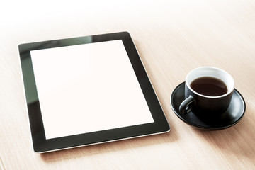 Tablet pc with blank screen on the desk with a cup of coffee