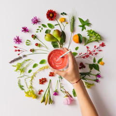 Various natural things neatly arranged in circle with smoothie