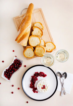 Baked Camembert with cranberries, white wine and toasted bread. Top view