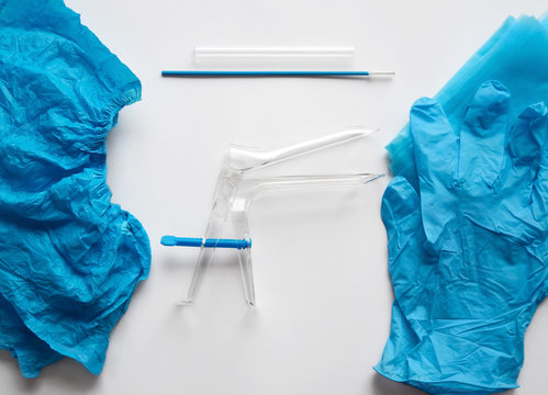 Disposable set for gynecological examination. From left to right are shoe covers, speculum, cervix brush, transport tube to deliver endocervical scraping to laboratory, gloves and draw sheet.