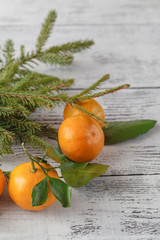 Fototapeta na wymiar fir branch and tangerines on the old wooden background