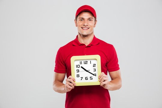 Young delivery man with clock