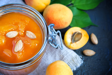 Fresh apricot jam in jar and ripe apricots close-up