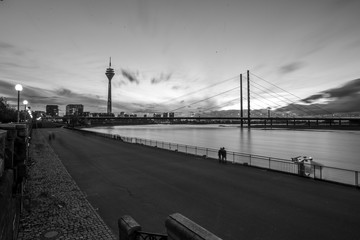 Beleuchtete Rheinkniebrücke in Düsseldorf an einem wolkenverhangenen Abend (schwarzweiß)