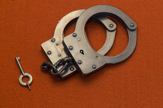 Metal Handcuffs on OrangeBackground