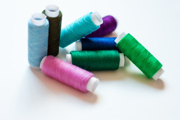Fototapeta na wymiar multicolored spools of thread on white background
