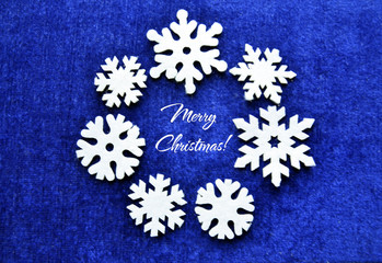Merry Christmas blue background with decorative felt snowflakes.Festive christmas decorations.Christmas wreath of snowflakes.Winter holidays background.Selective focus.