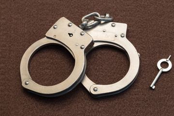 Metal Handcuffs on Brown